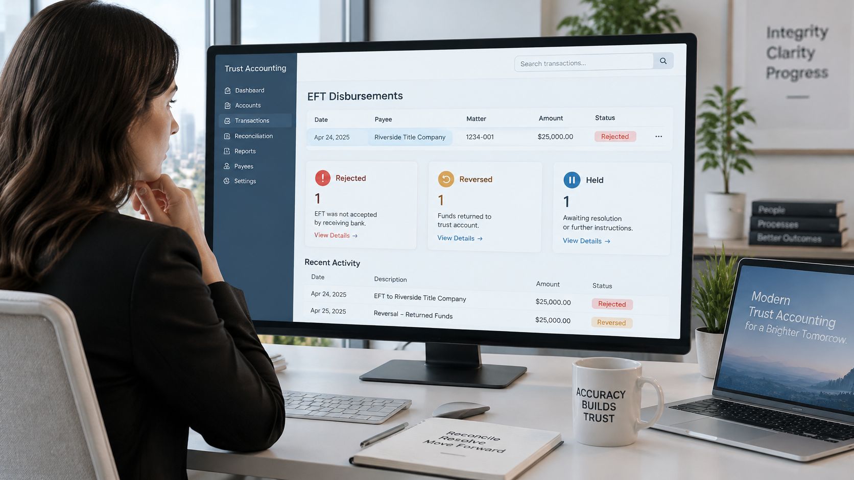 A professional woman viewing trust accounting software on a desktop computer monitor in a modern office.